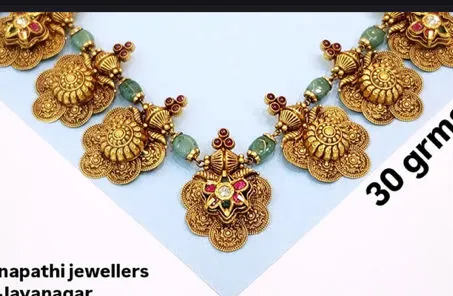 An antique necklace with green beads, captioned 30 grams