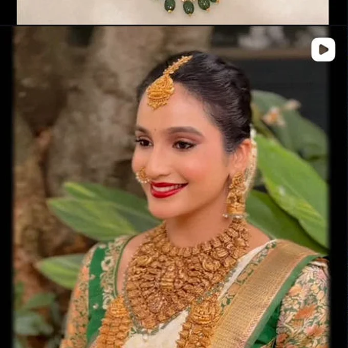 A bride in a green blouse wearing layered antique gold, tikka to haram, from the shop's own page