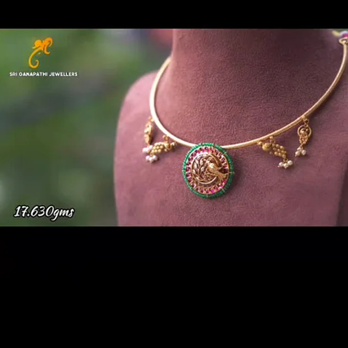 A hasli necklace with peacock pendant on a dark bust, captioned 17.630 grams on their reel