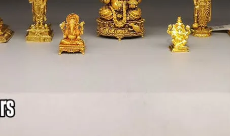 A row of small gold idols: Balaji, Ganesha and Lakshmi