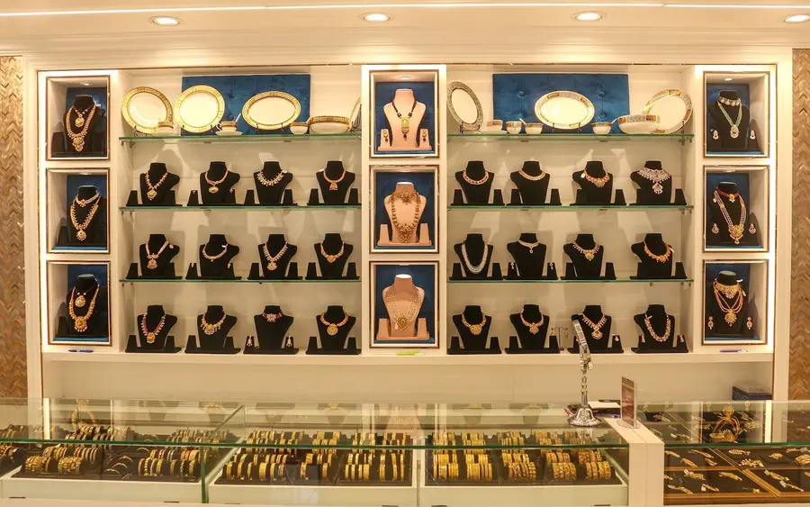 Blue velvet niches holding necklace busts, silver thalis on the upper shelves.